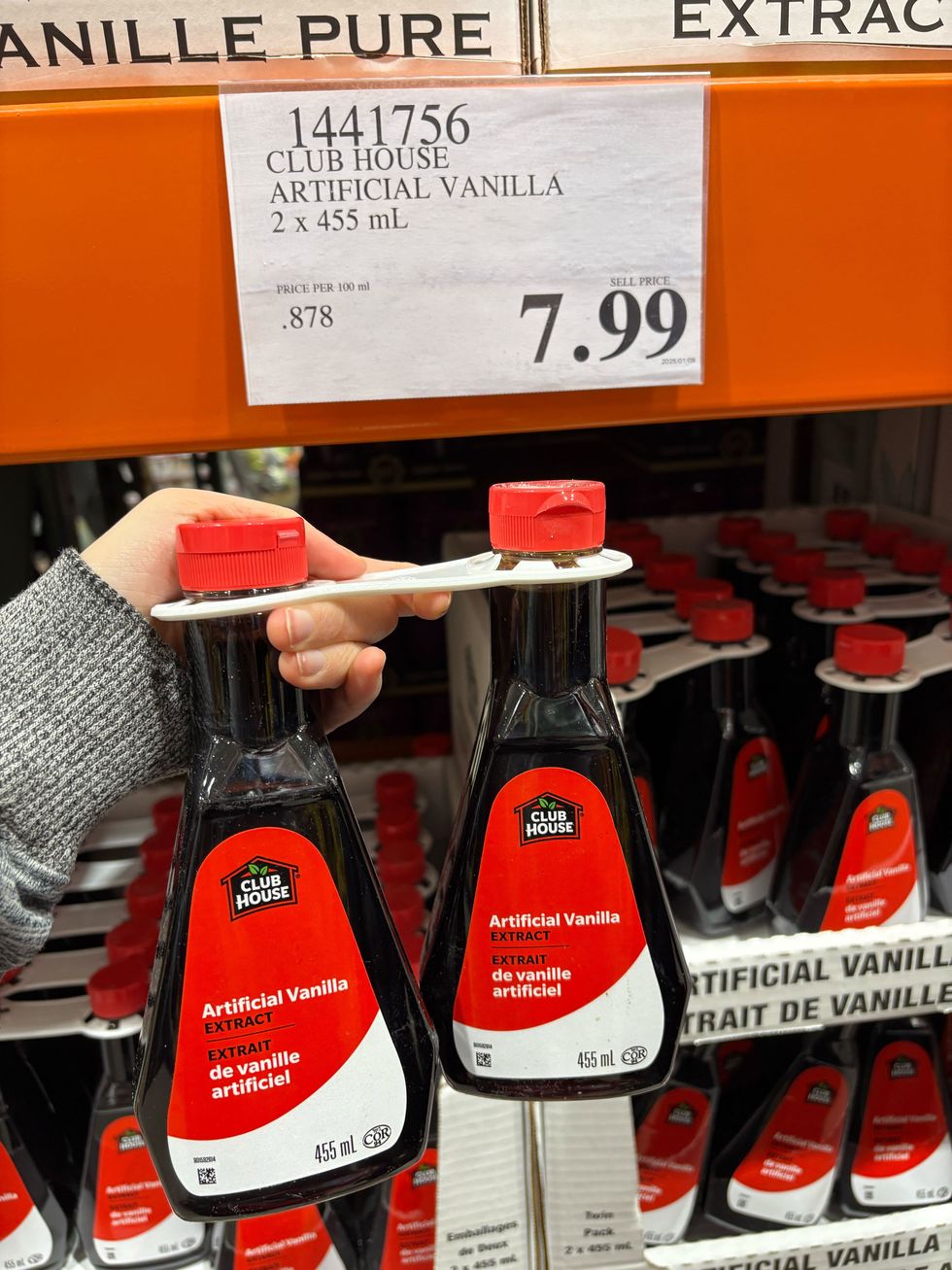 person holding bottles of club house vanilla extract at costco