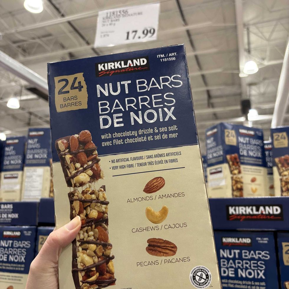 person holding box of Kirkland Signature nut bars at costco