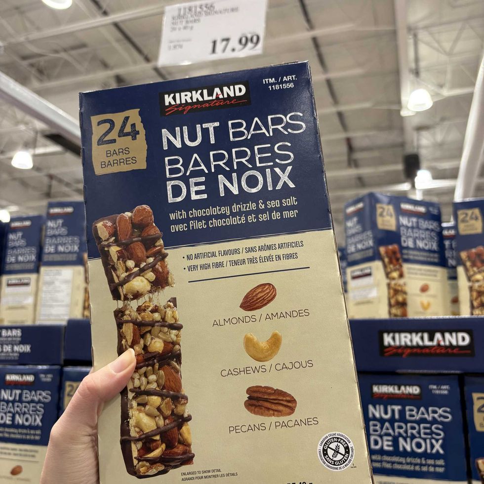 person holding box of Kirkland Signature nut bars at costco