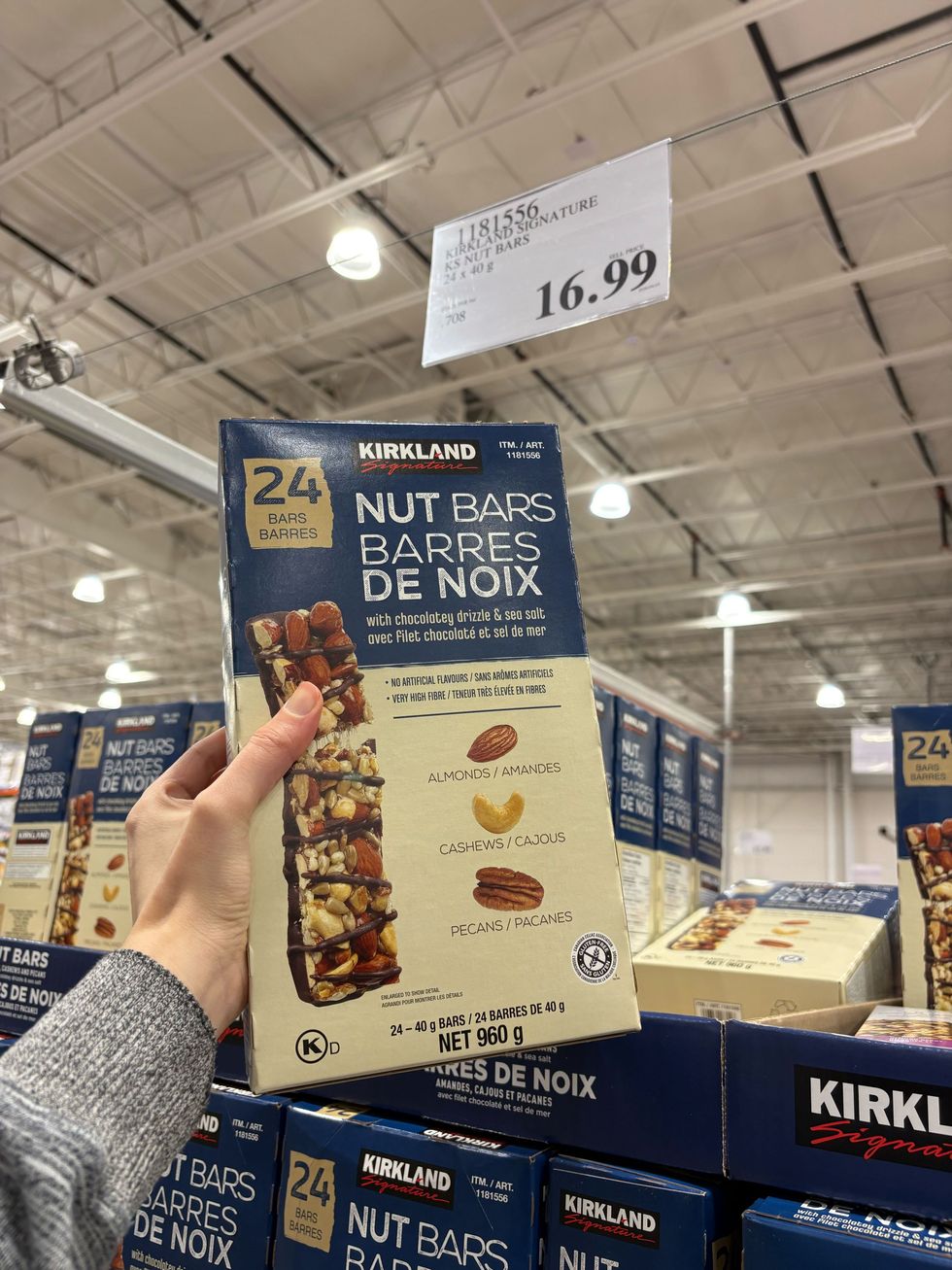 person holding box of kirkland signature nut bars