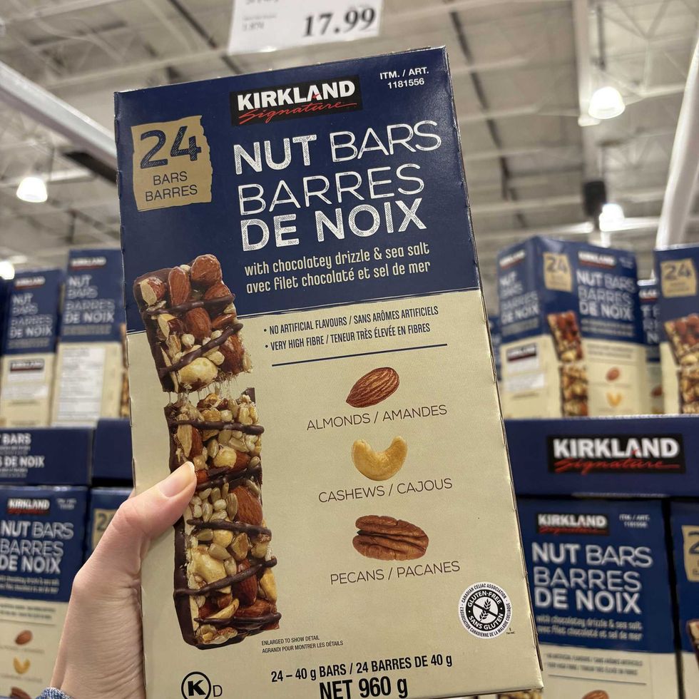 person holding box of \u200bKirkland Signature nut bars at costco