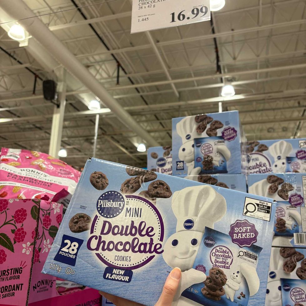 person holding box of \u200bPillsbury mini double chocolate cookies at costco