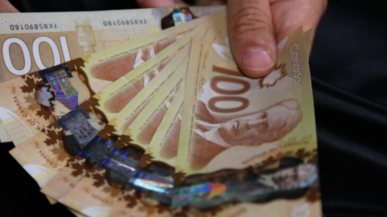 Person holding Canadian $100 bills.