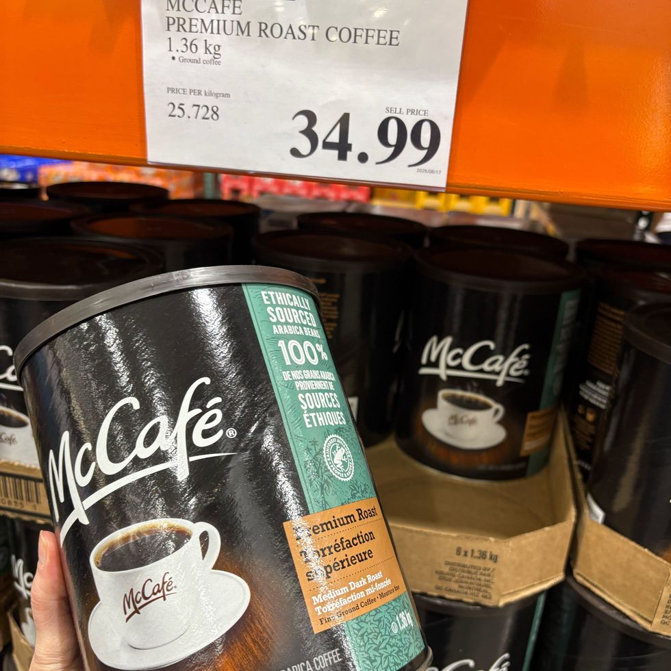 person holding canister of McCafe ground coffee at cotsco