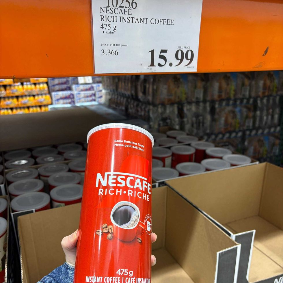 person holding canister of Nescafe instant coffee at costco