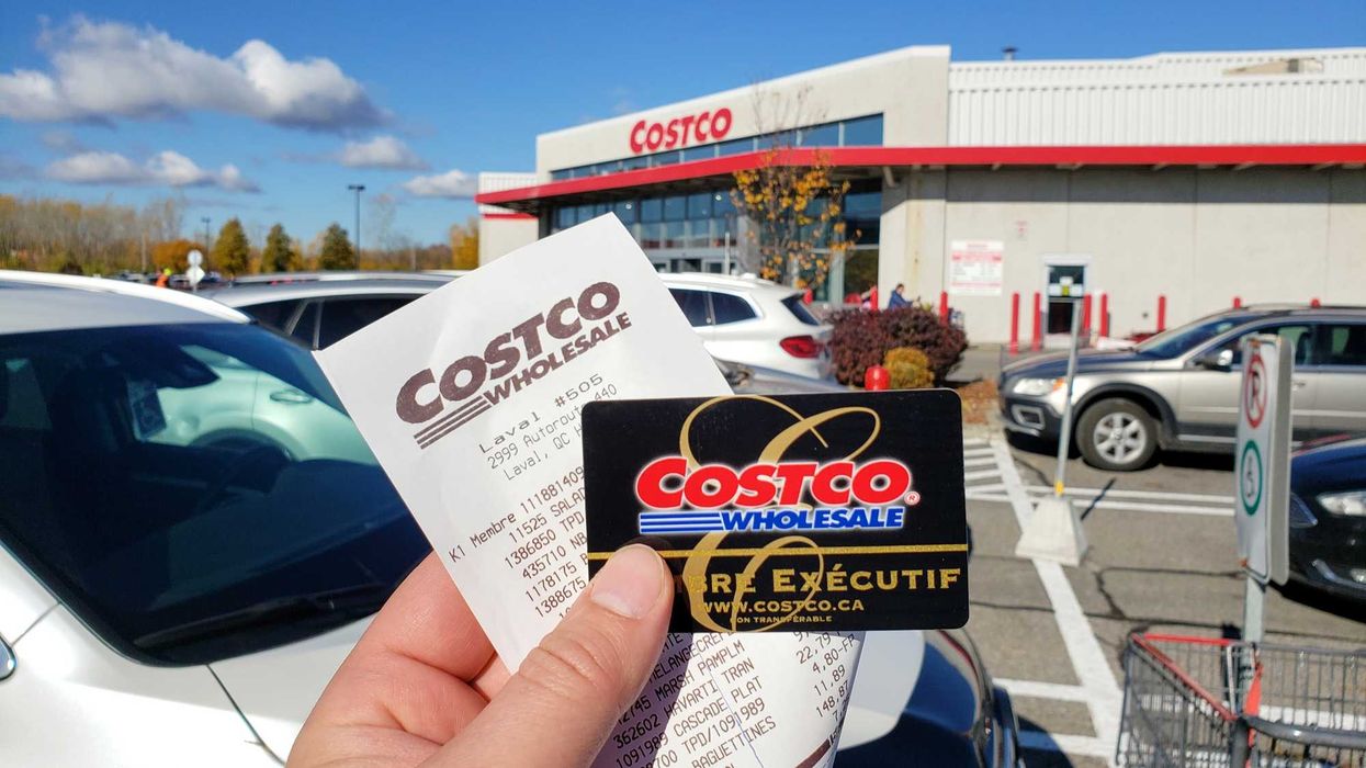 person holding costco executive membership card and receipt outside of costco store in canada