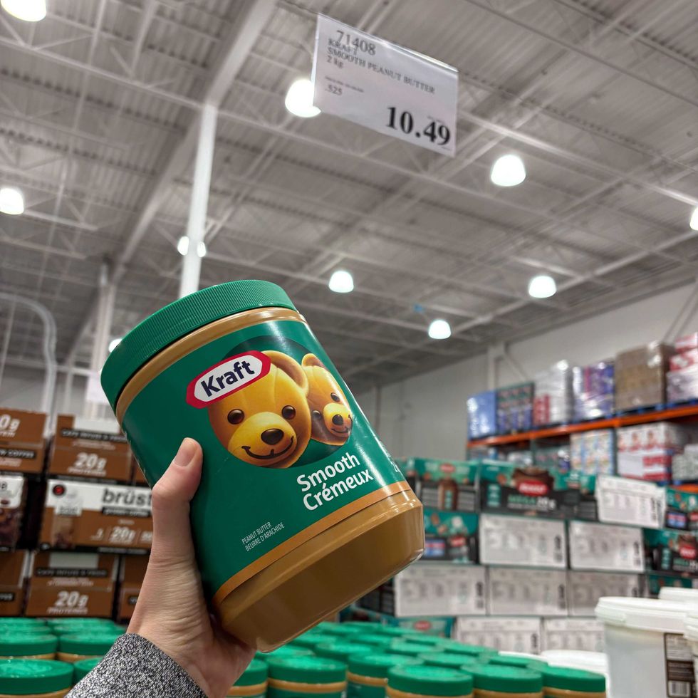person holding jar of kraft peanut butter at costco business centre