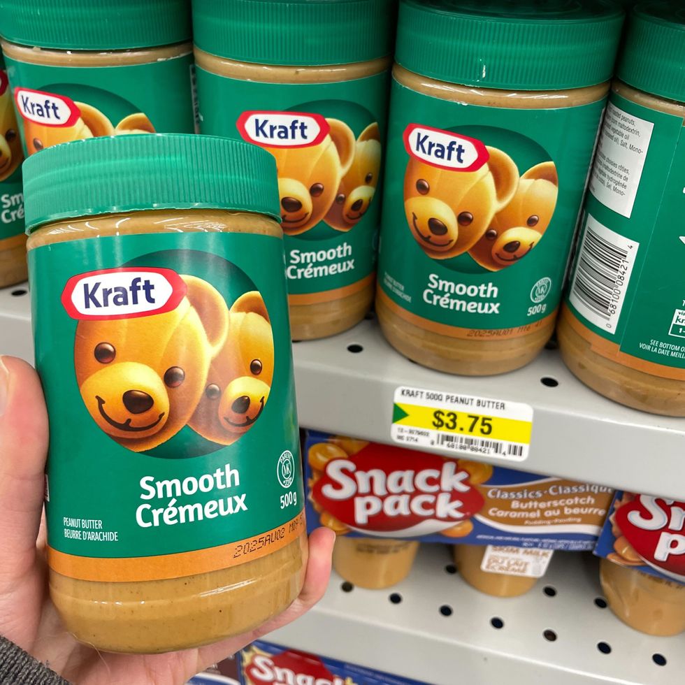 person holding jar of kraft peanut butter at dollarama