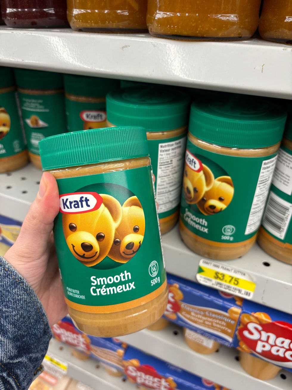 person holding jar of kraft peanut butter at dollarama