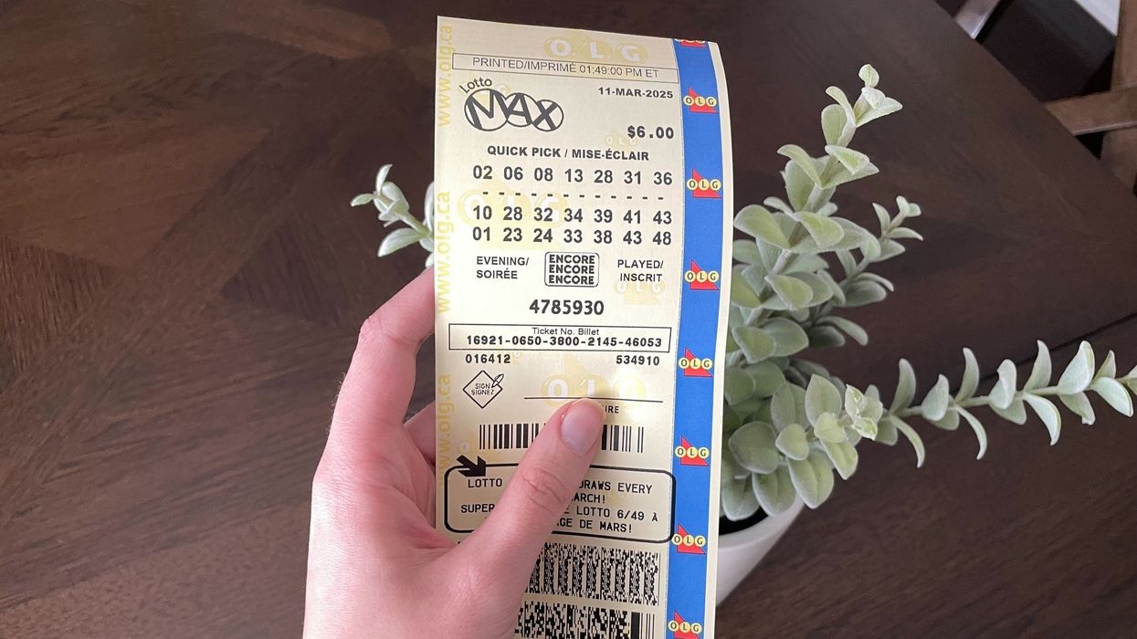 person holding lotto max ticket from olg
