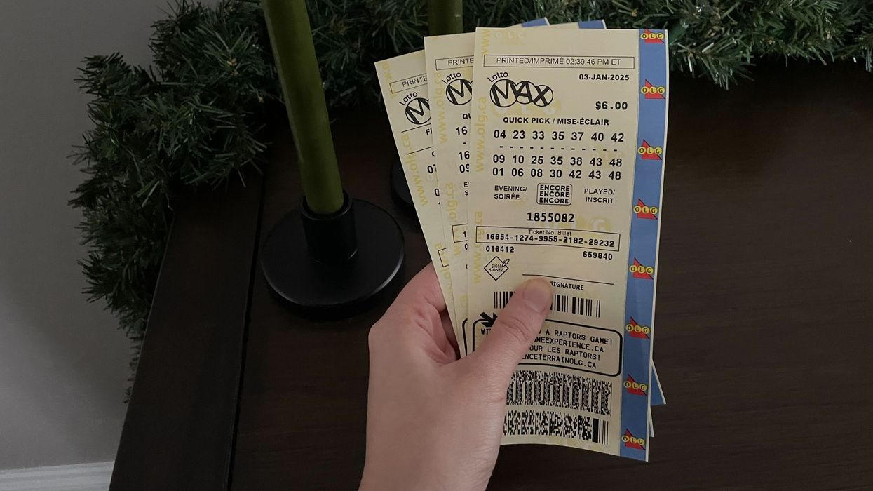 person holding lotto max tickets