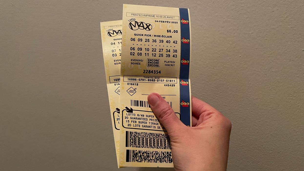 person holding lotto max tickets