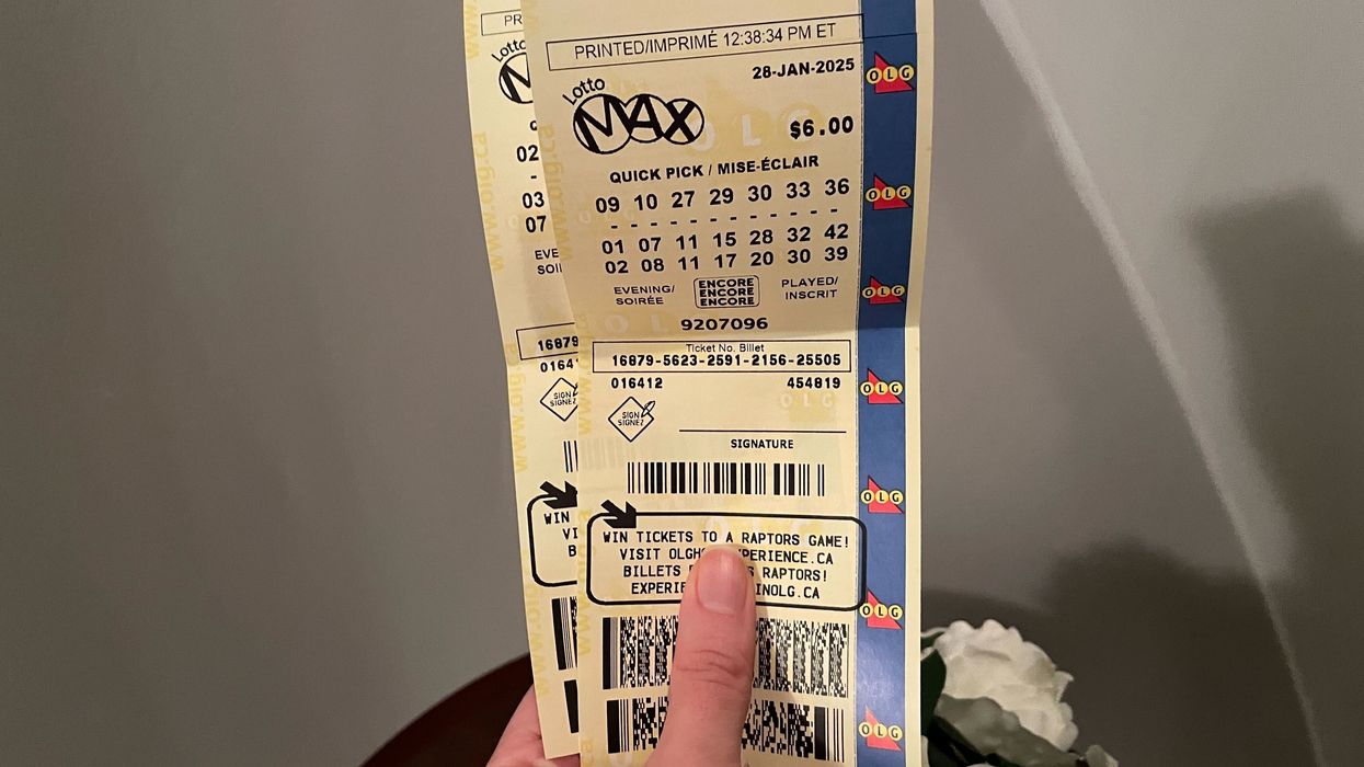 person holding lotto max tickets