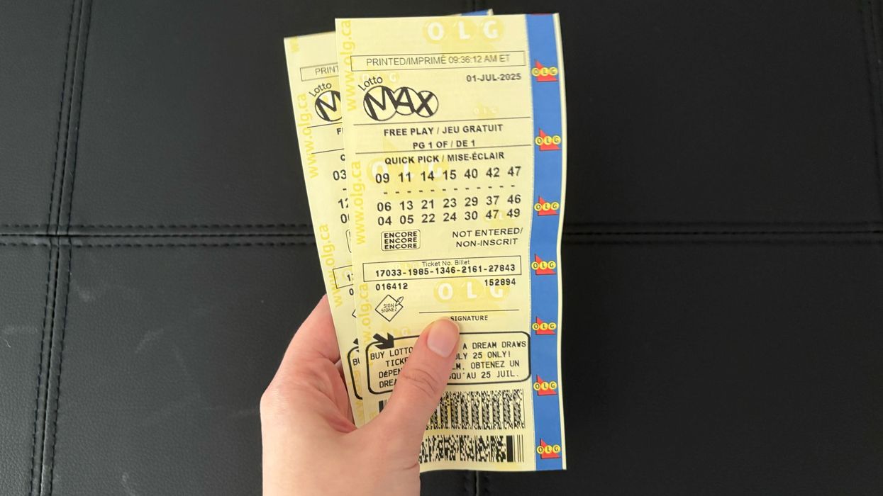 person holding lotto max tickets