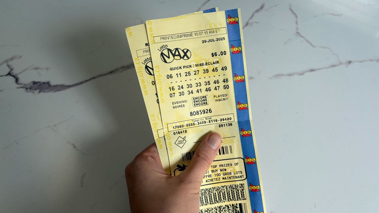 person holding lotto max tickets