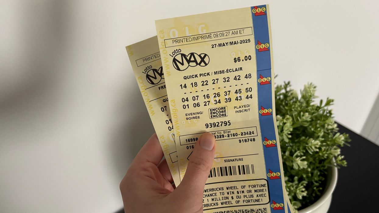 person holding lotto max tickets