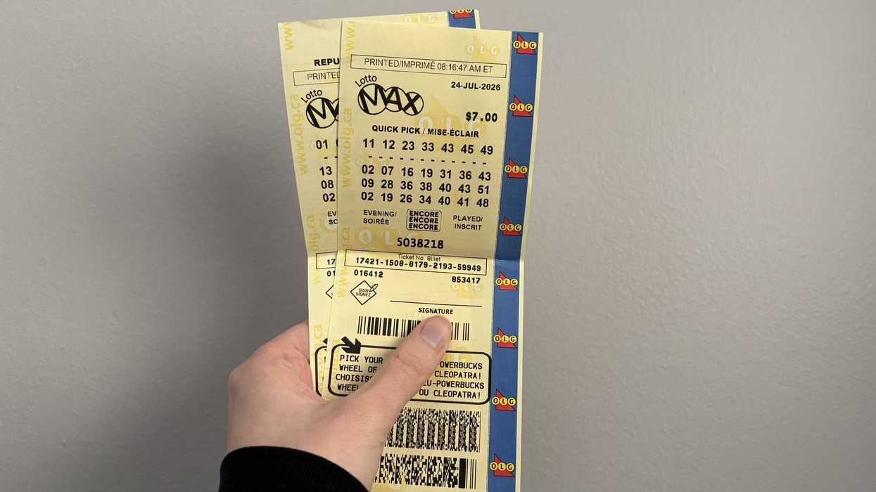 person holding lotto max tickets
