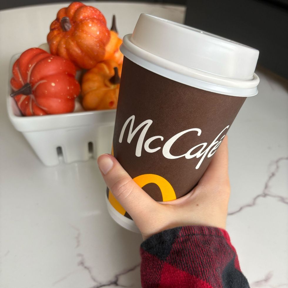 person holding mcdonald's mccafe cup filled with a psl