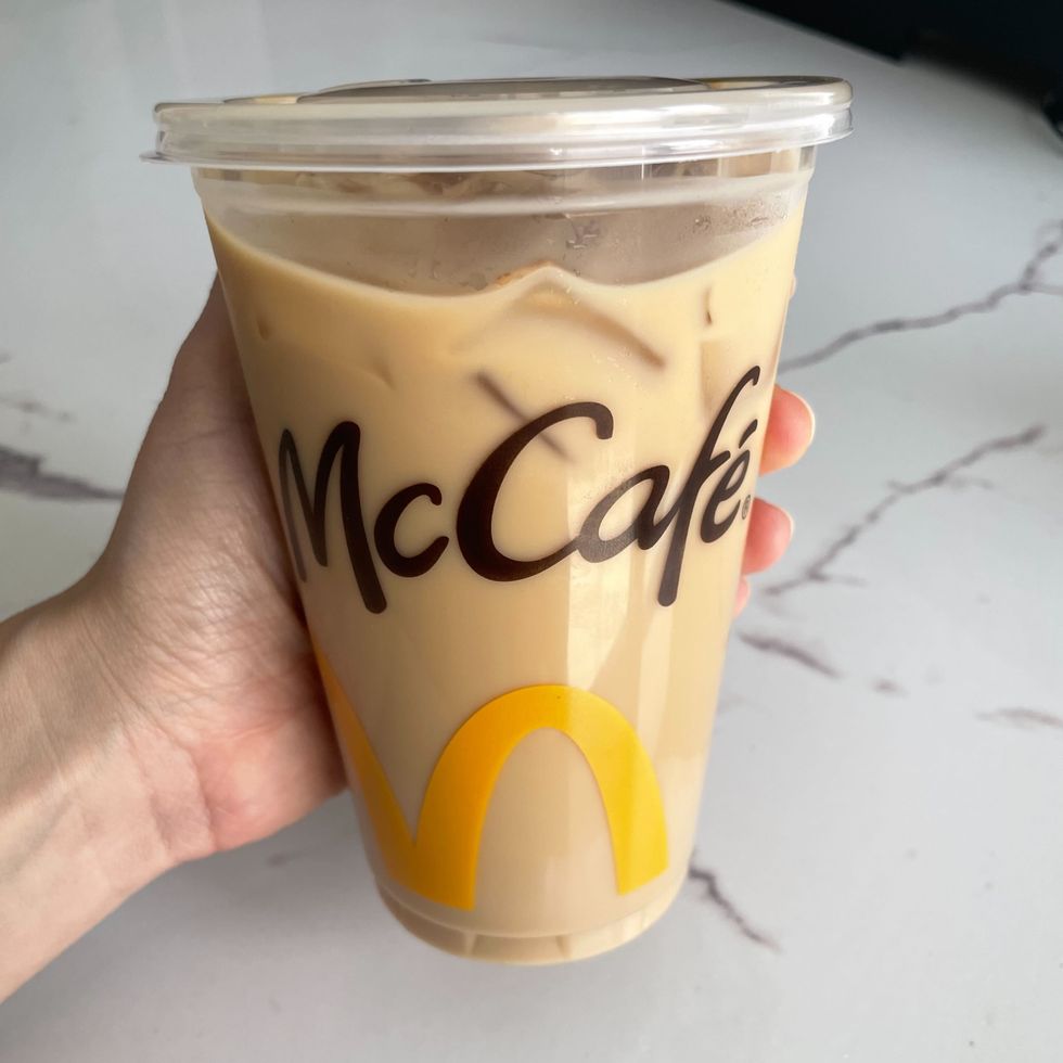 person holding mcdonald's mccafe iced coffee