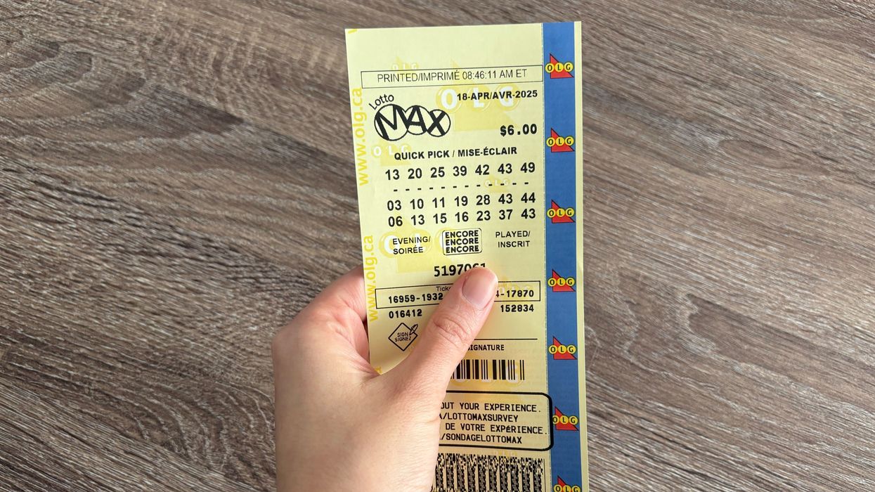 person holding olg lotto max ticket