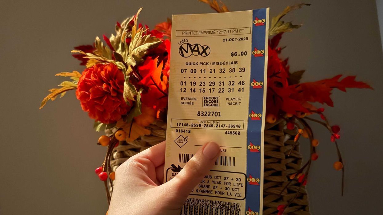 person holding olg lotto max ticket