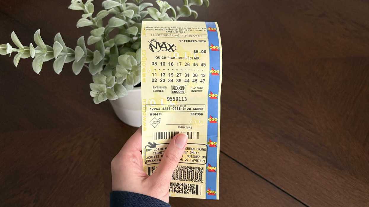 person holding olg lotto max ticket