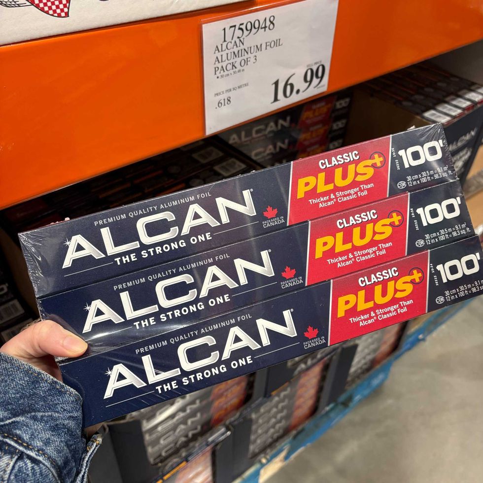 person holding pack of Alcan aluminum foil at costco