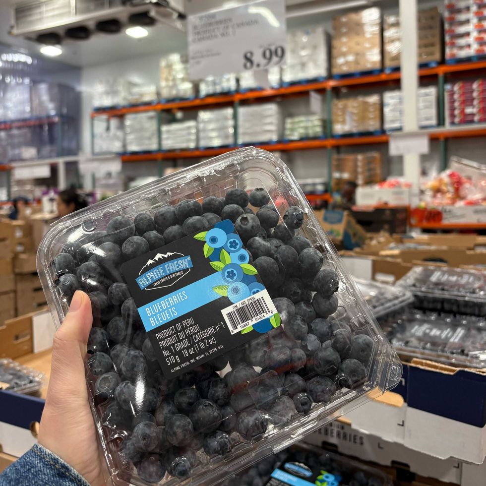 person holding pack of blueberries at costco