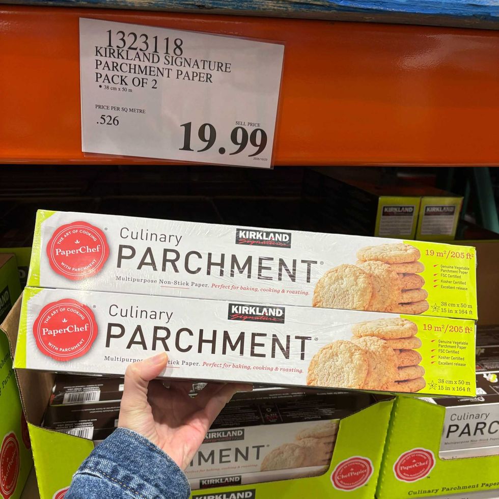person holding pack of Kirkland Signature PaperChef parchment paper at costco