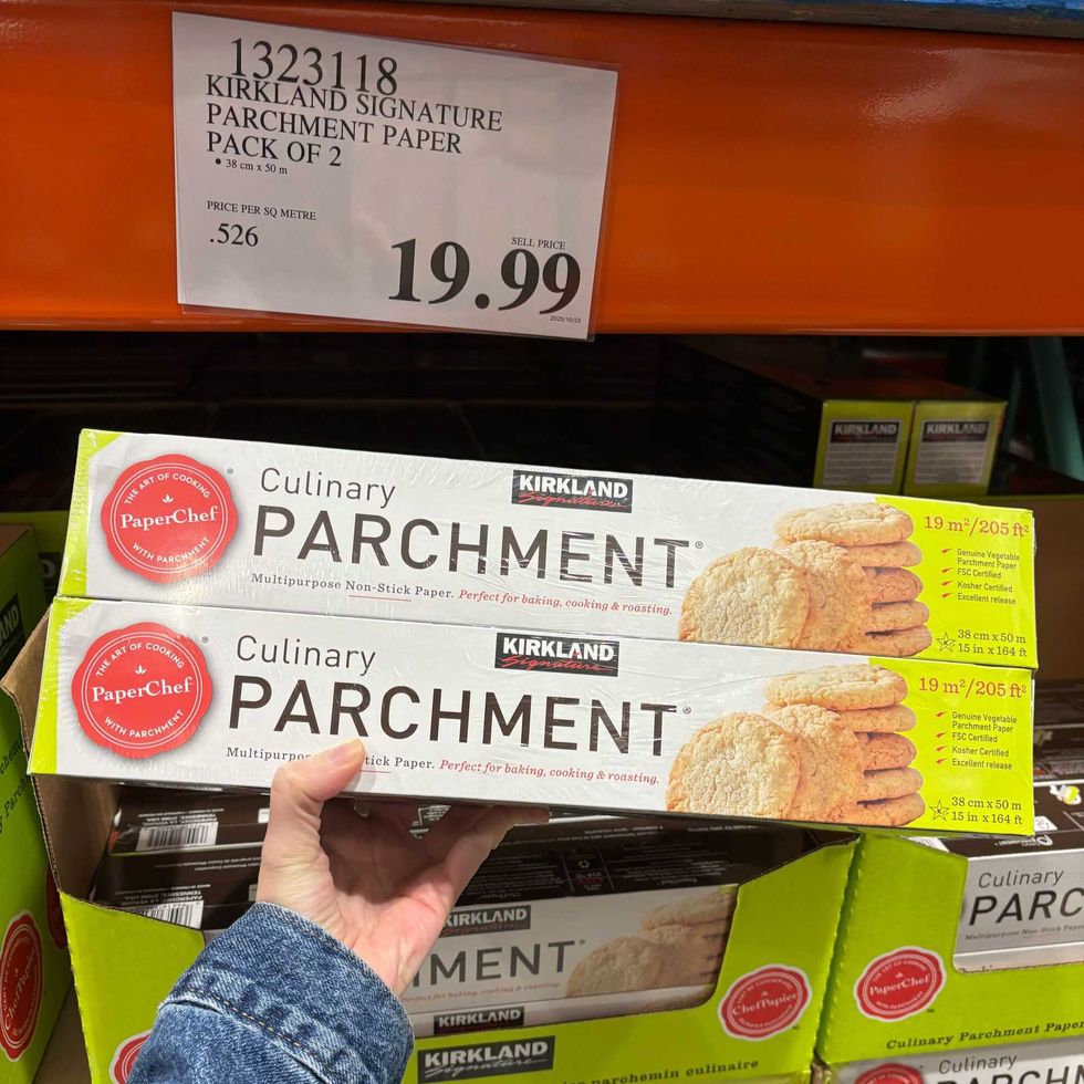 person holding pack of Kirkland Signature PaperChef parchment paper at costco