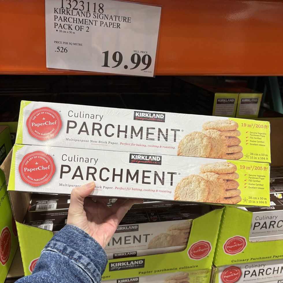 person holding pack of Kirkland Signature parchment paper at costco