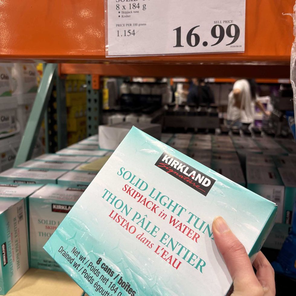 person holding pack of Kirkland Signature tuna at Costco