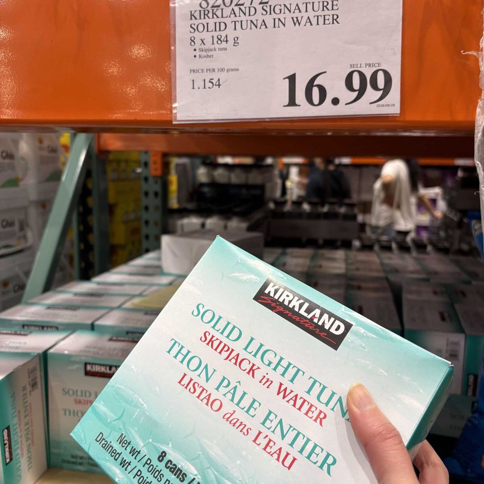person holding pack of Kirkland Signature tuna at costco