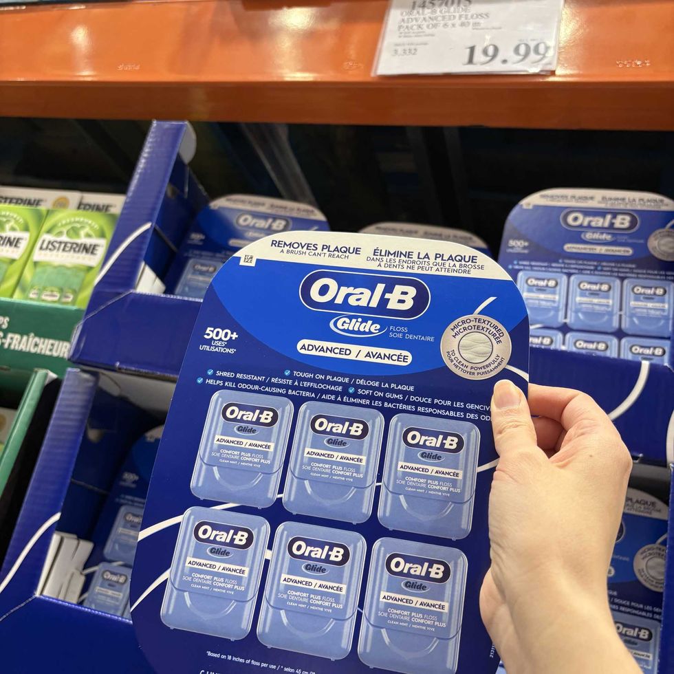 person holding pack of Oral-B dental floss at Costco