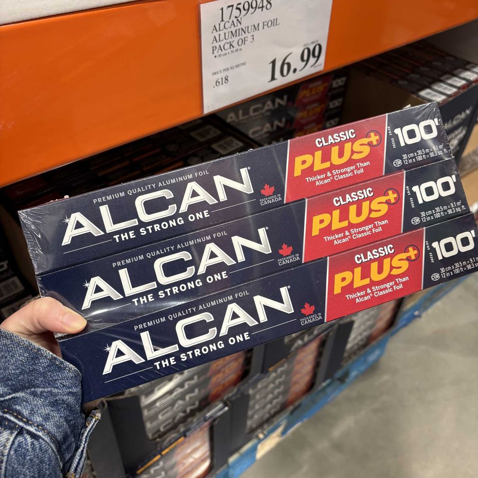 person holding pack of \u200bAlcan aluminum foil at Costco