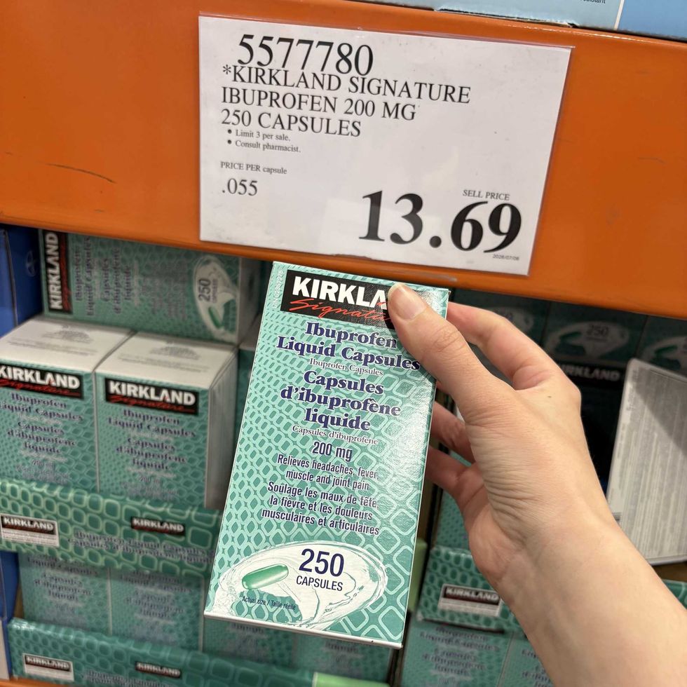 person holding pack of \u200bKirkland Signature ibuprofen at costco