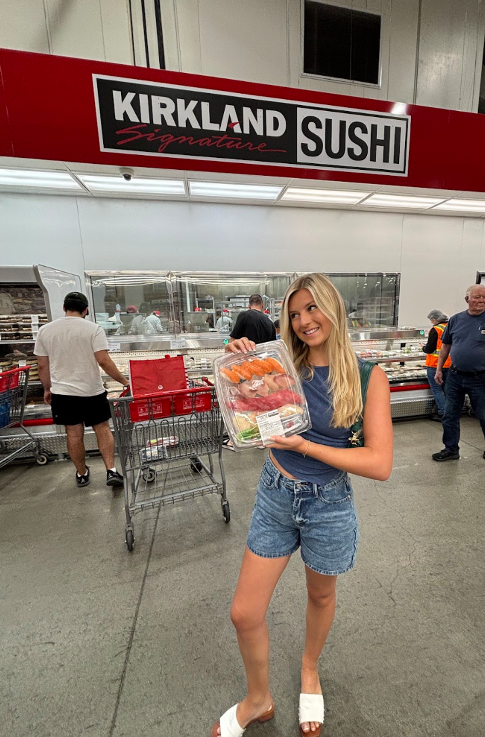 Person holding sushi at a store. 