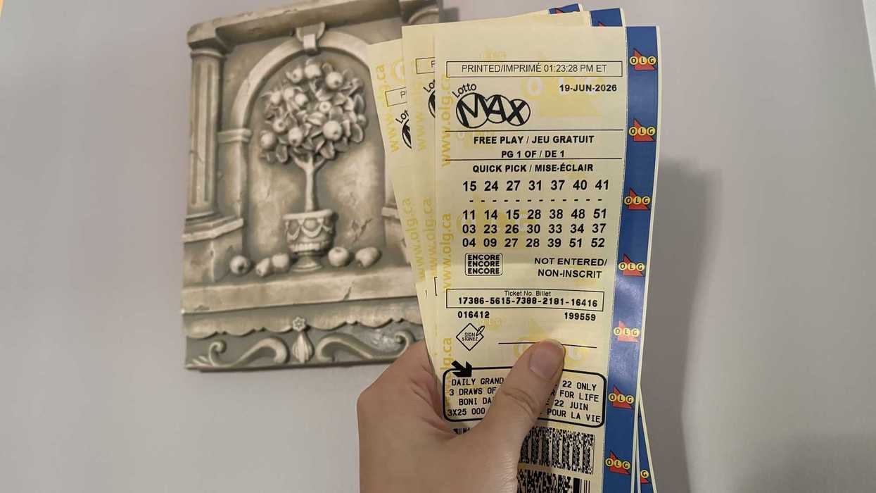 person holding three lotto max tickets from olg