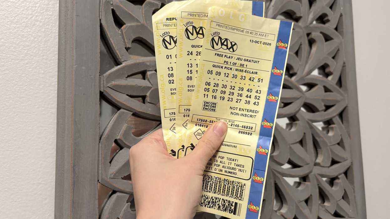 person holding three lotto max tickets from olg