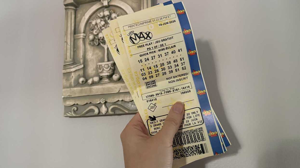 person holding three lotto max tickets