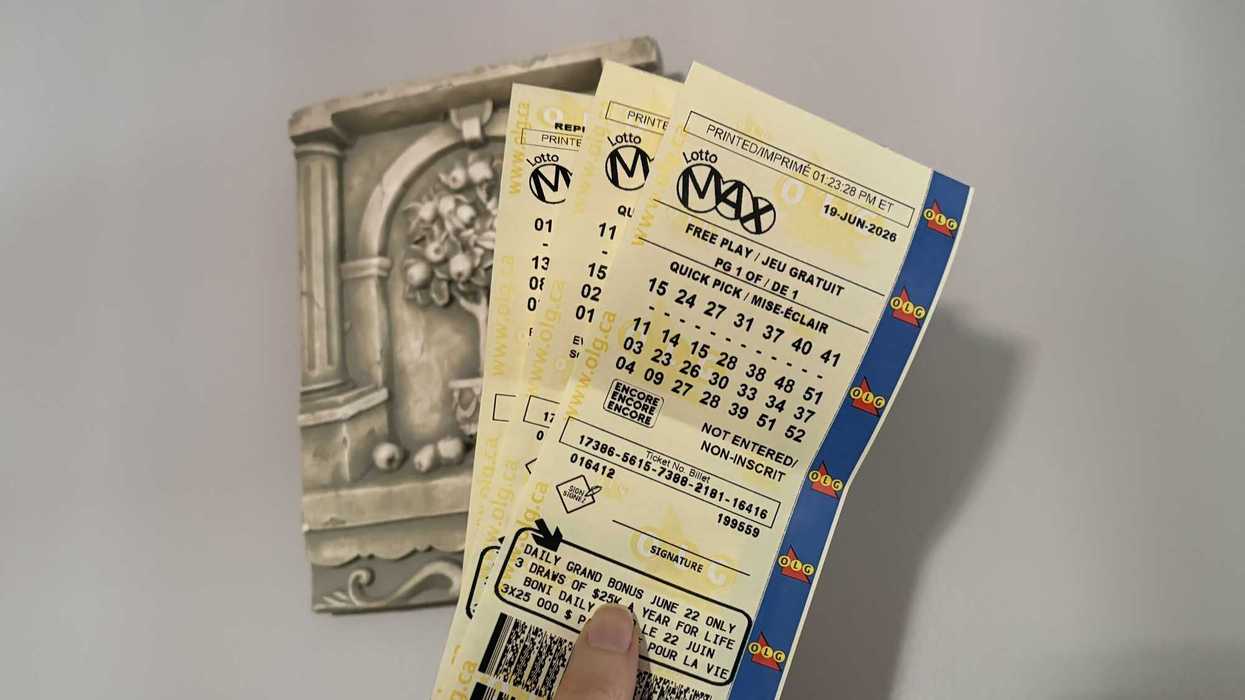 person holding three lotto max tickets