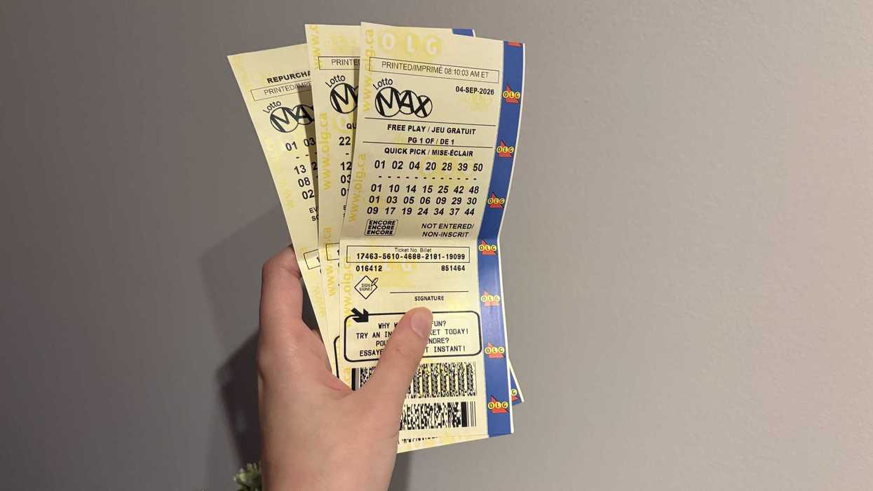 person holding three lotto max tickets