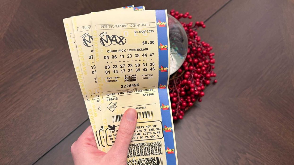 person holding three olg lotto max tickets