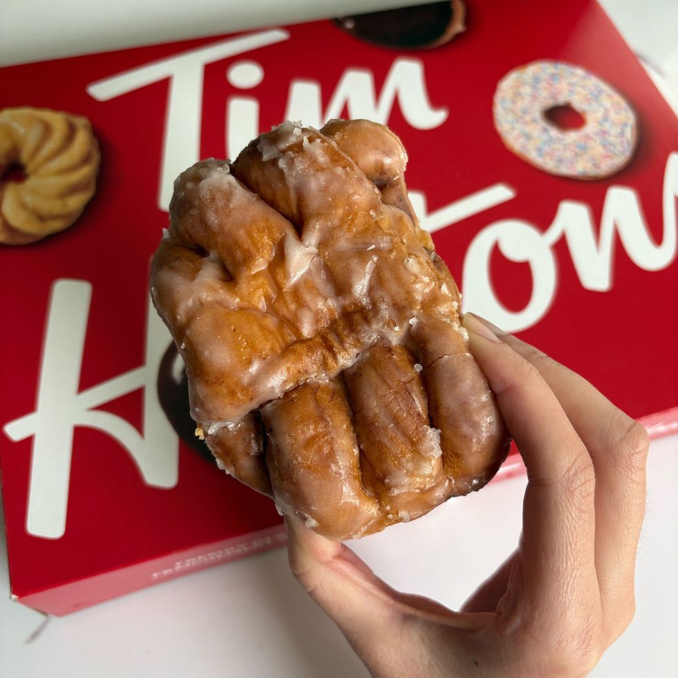 person holding tim hortons apple fritter