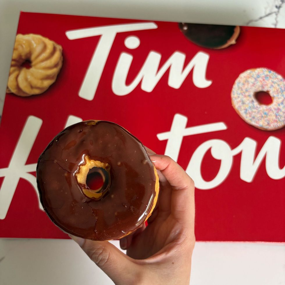 person holding tim hortons chocolate dip donuts