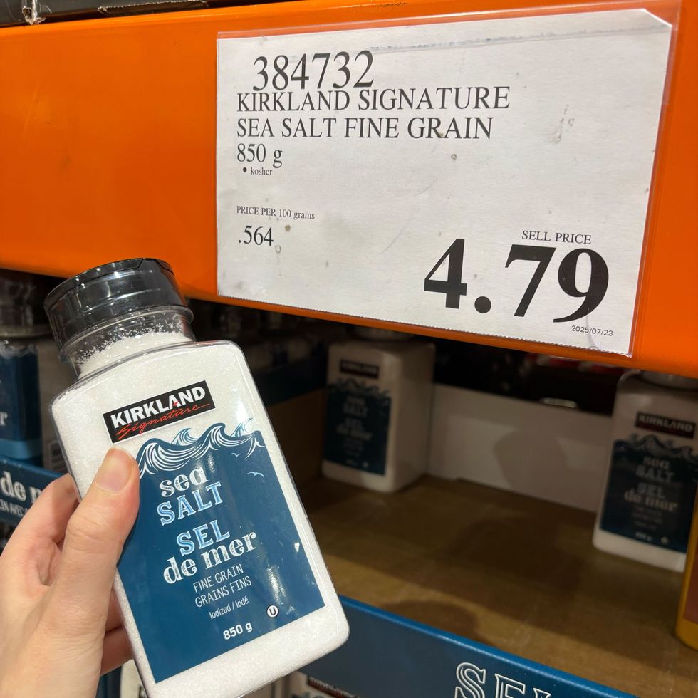 person holding tub of Kirkland Signature fine sea salt