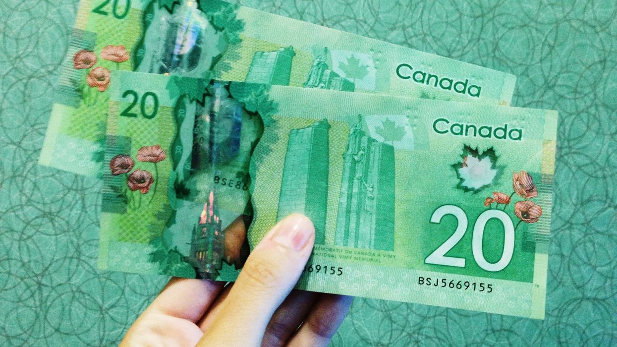 Person holding two Canadian $20 bills.