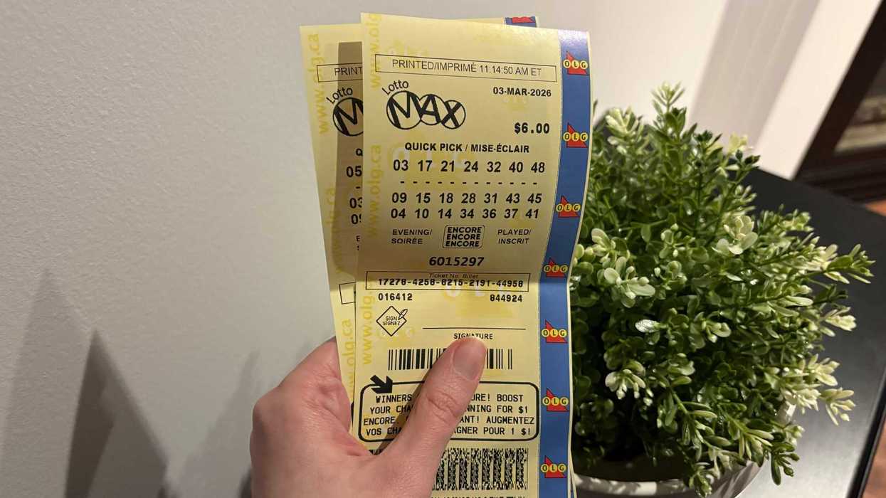 person holding two lotto max tickets from olg