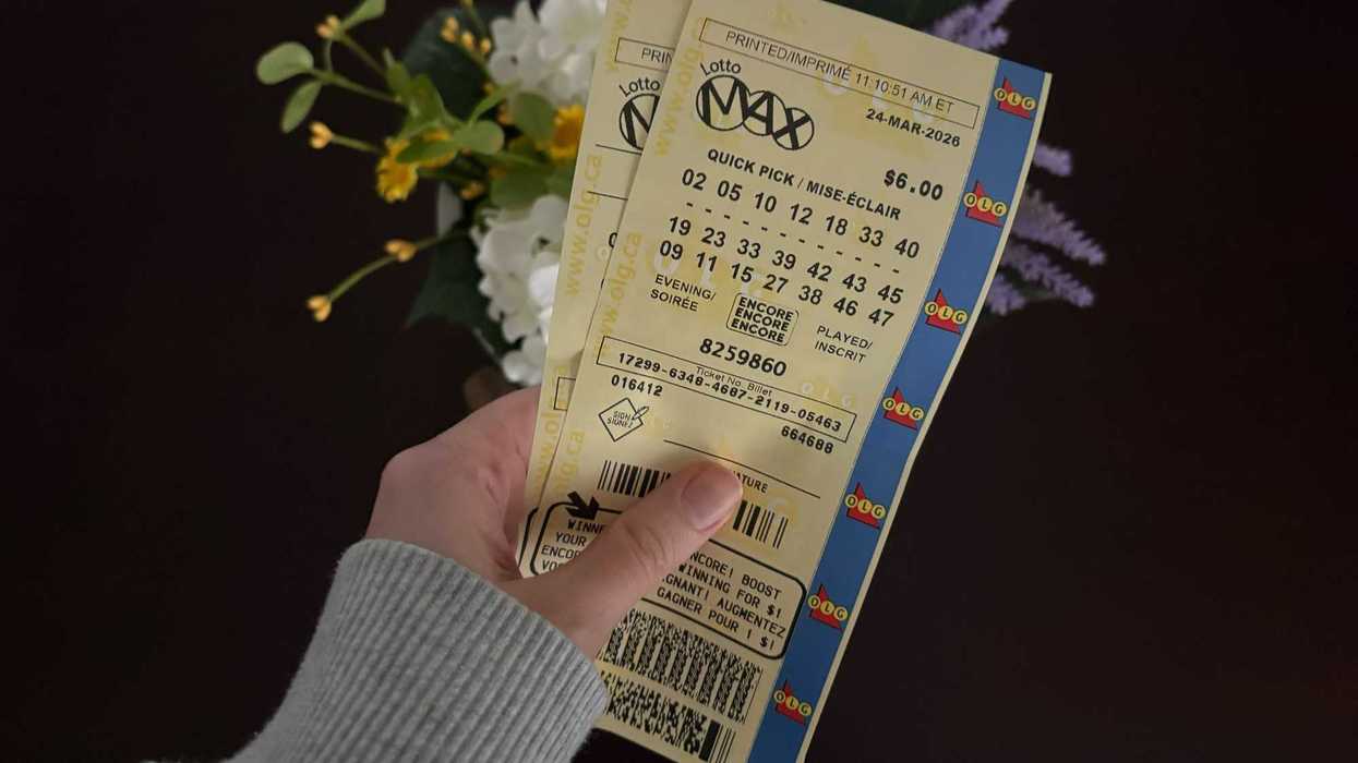 person holding two lotto max tickets from olg