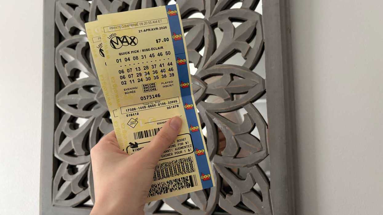 person holding two lotto max tickets
